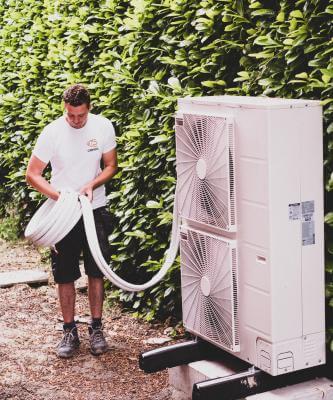 Foto van Sven die aan airco unit werkt.