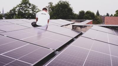 Foto van Sven die aan zonnepanelen werkt.